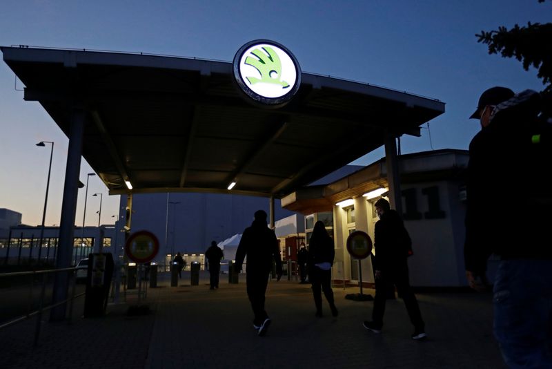 Workers enter Skoda Auto’s factory as the company restarts production