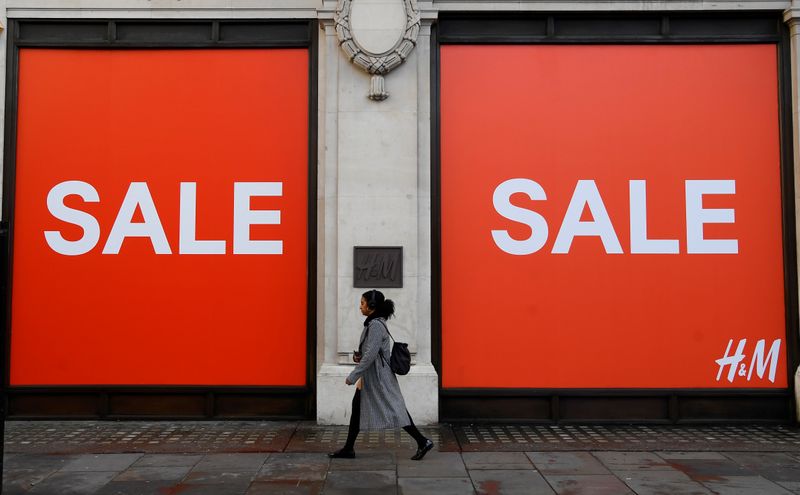 A woman walks past a sale sign on a branch
