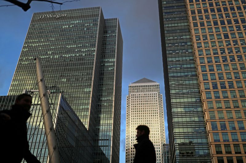 FILE PHOTO: People walk through the Canary Wharf financial district