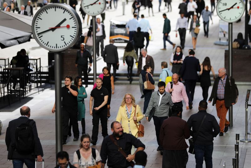People walk through the financial district of Canary Wharf, London,