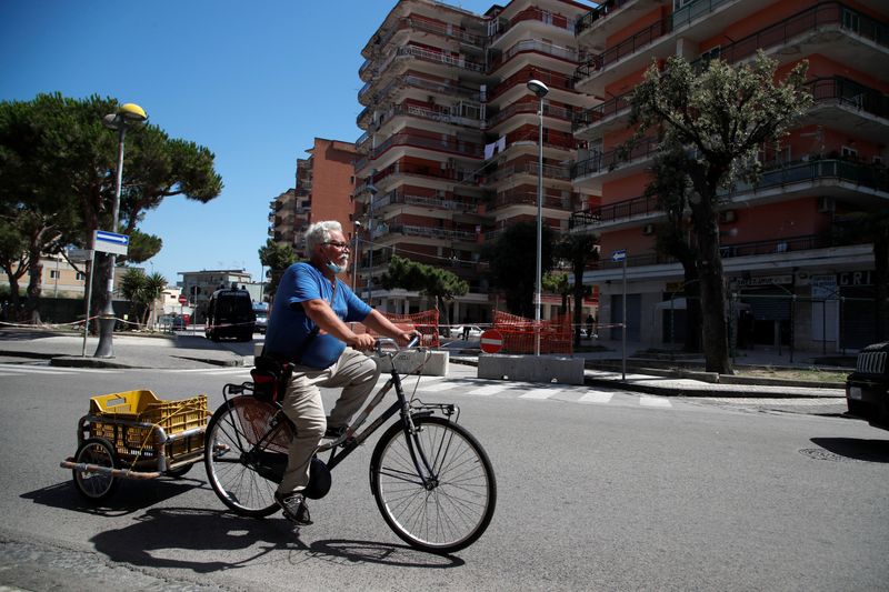 A man rides his bicycle near a residential complex where