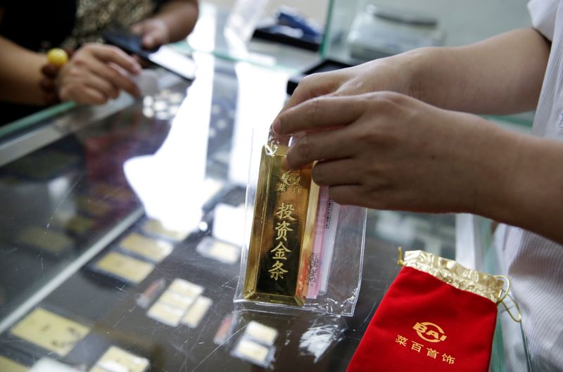 A sales assistant packs a 1000 gram gold bar for