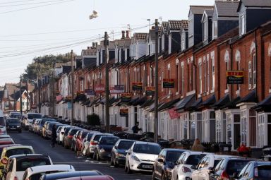 FILE PHOTO: Estate agent’s signs hang from houses in the