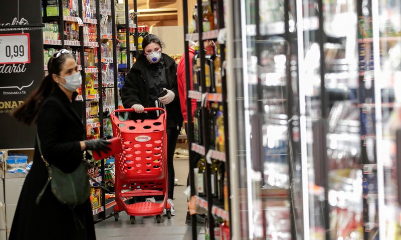 People wearing protective face masks are seen in a supermarket