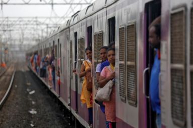 Women commuters travel by a suburban train as they head