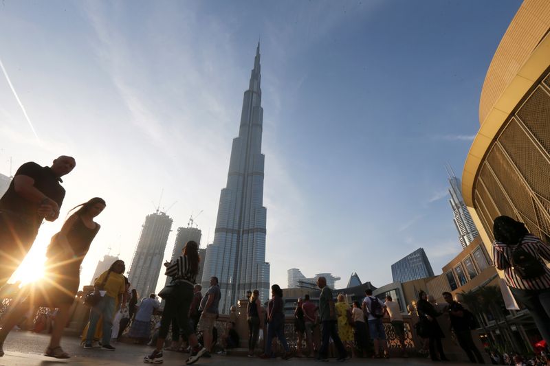 People are seen in front of Burj Khalifa, the world