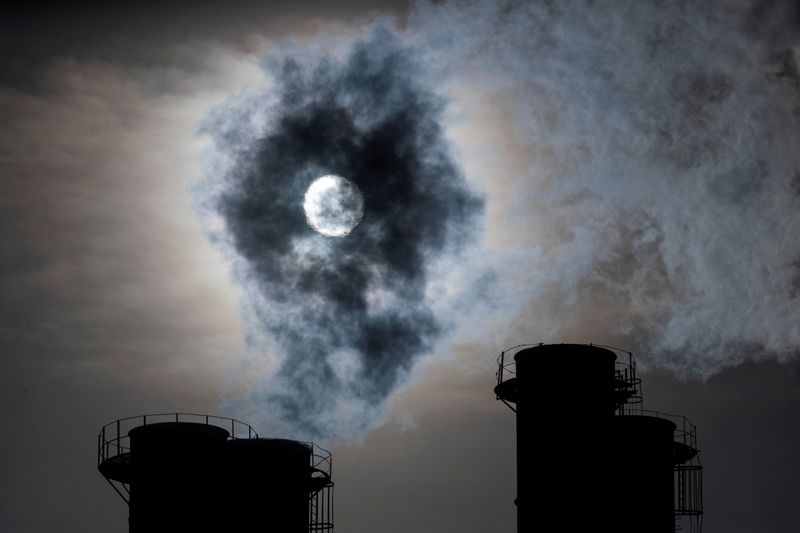 FILE PHOTO: Sun shines through steam rising from chimneys of
