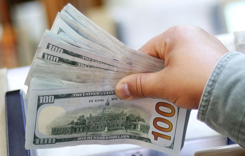 An employee counts U.S. dollar bills at a money exchange
