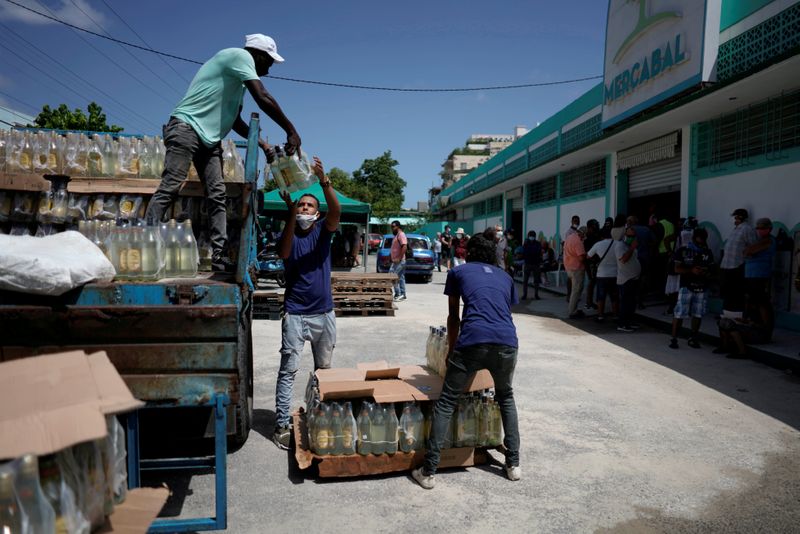 FILE PHOTO: Workers unload products at the first wholesale outlet