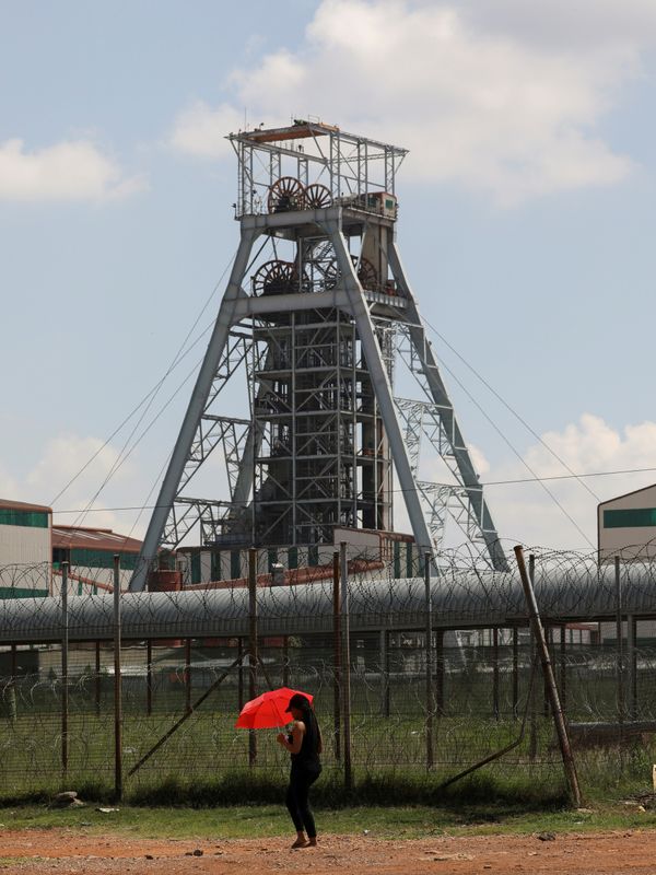 FILE PHOTO: A woman walks past a shaft at Harmony