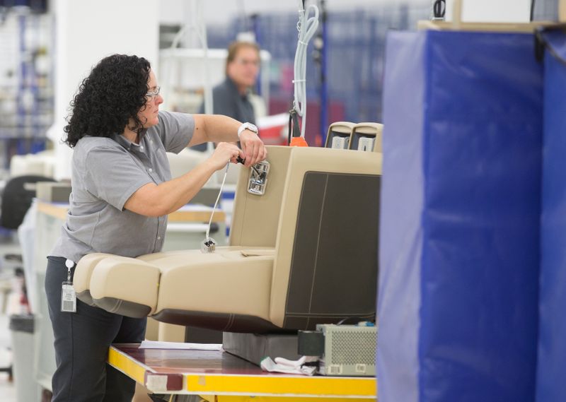 A Bombardier Global employee works on fitting a seat for