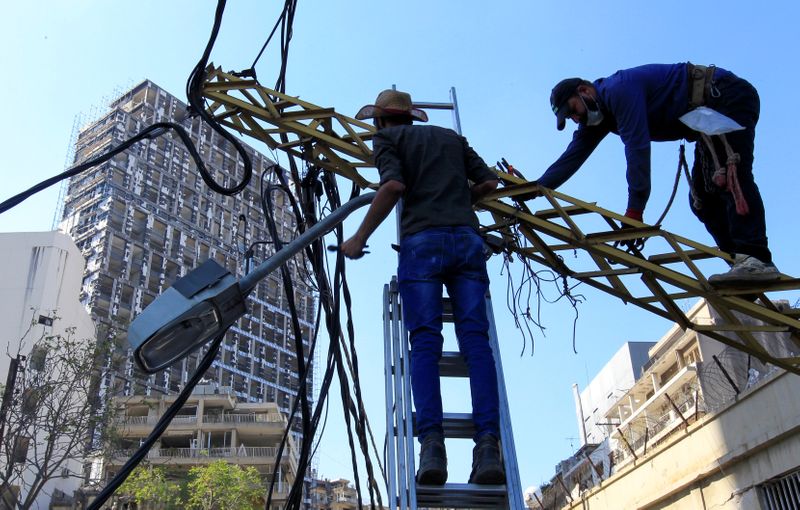 Workers fix damaged cables following Tuesday’s massive blast in Beirut’s