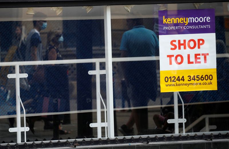 FILE PHOTO: Shoppers are reflected in the window of a