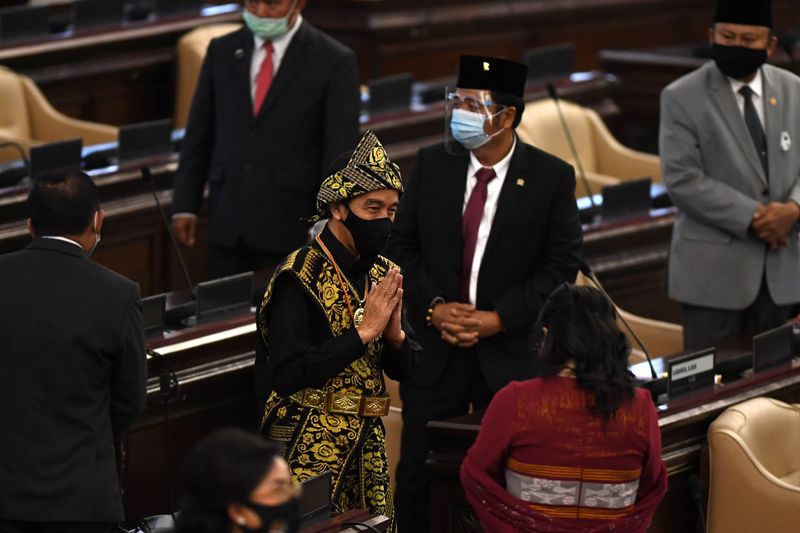 Indonesian President Joko Widodo wearing protective mask salutes to Indonesian