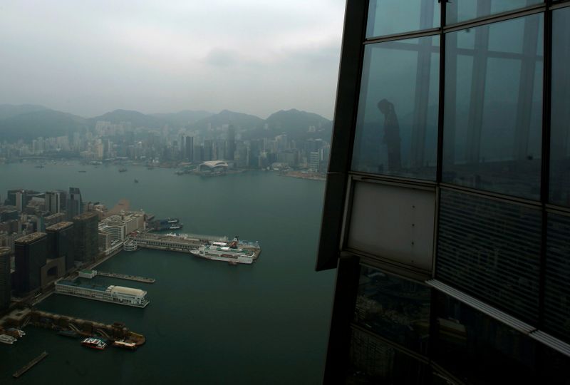 A worker at “sky100” looks at Hong Kong’s Victoria Harbour