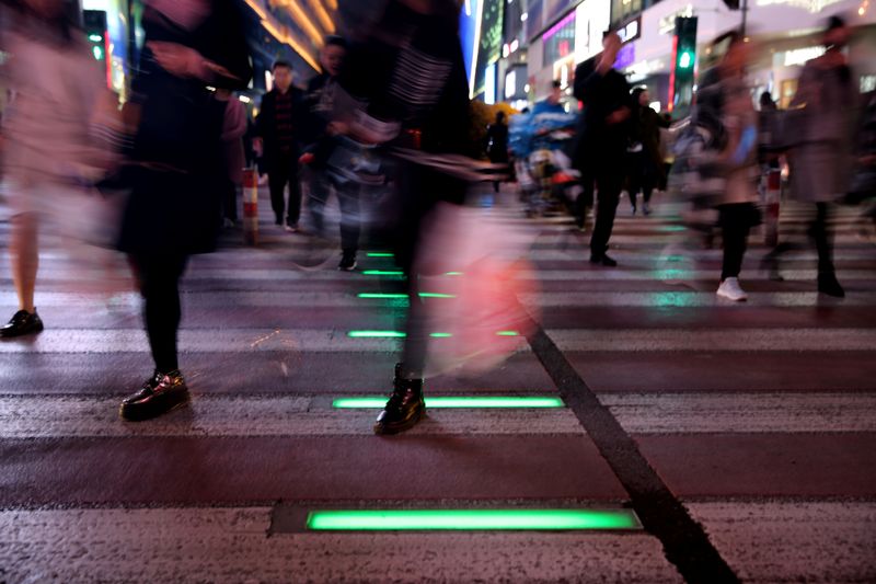 People walk on a crossing with light signals for pedestrians