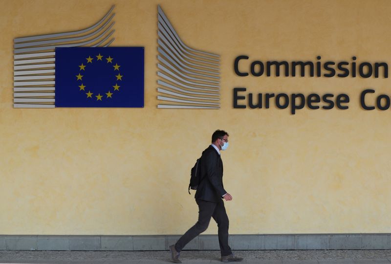 Man wearing a protective mask walks past the EU Commission