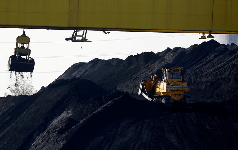 FILE PHOTO: A bulldozer works on a heap of coal