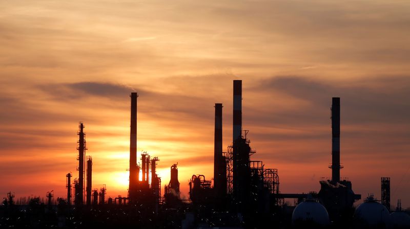 FILE PHOTO: The sun sets behind the chimneys of the
