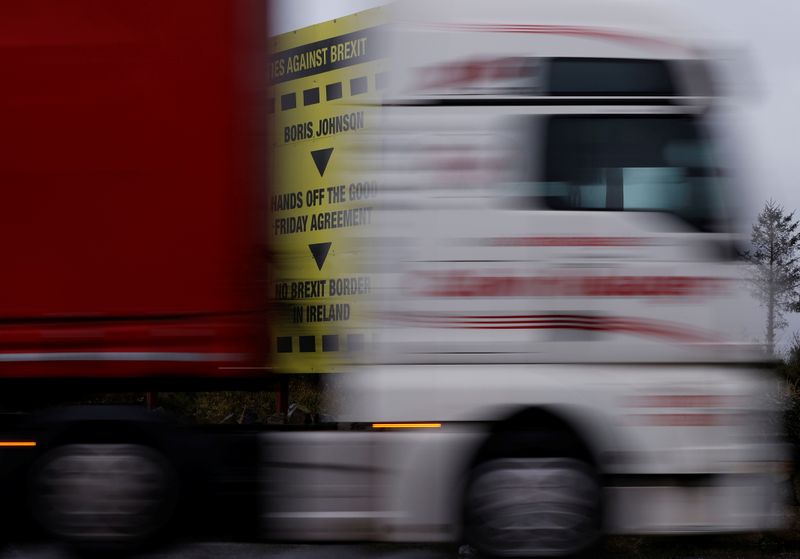A lorry passes a Brexit themed poster on the road