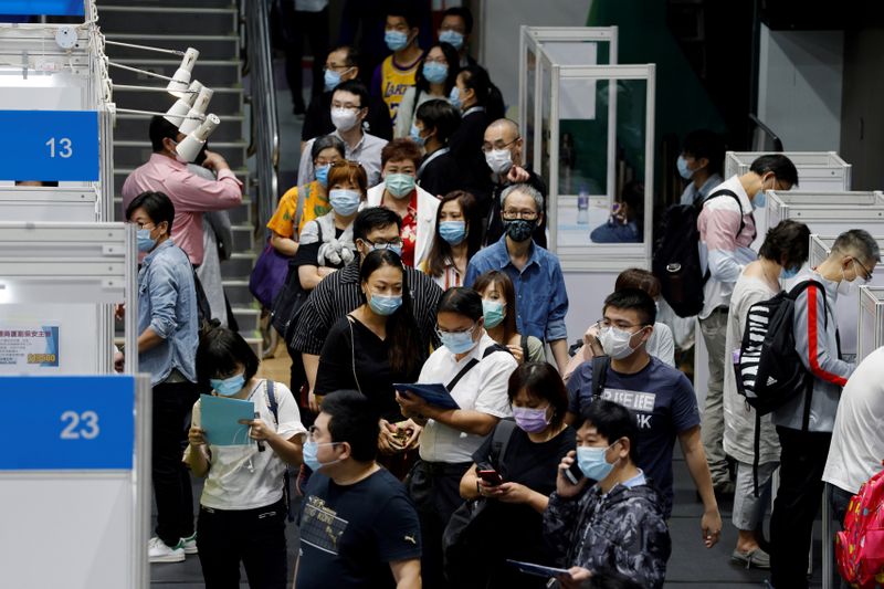 FILE PHOTO: Job seekers wearing face masks fill in forms
