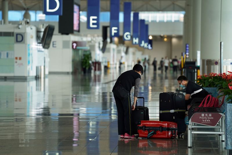 FILE PHOTO: Woman sorts luggage at Hong Kong International Airport