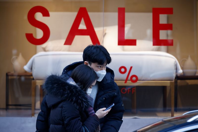 FILE PHOTO: A couple wearing masks walk in a shopping