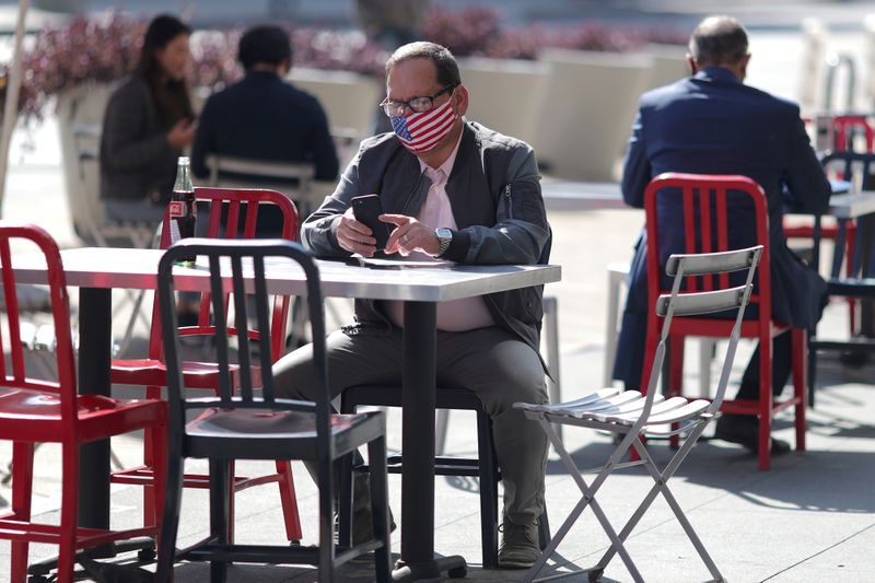 FILE PHOTO: A man sits at an outdoor dining table