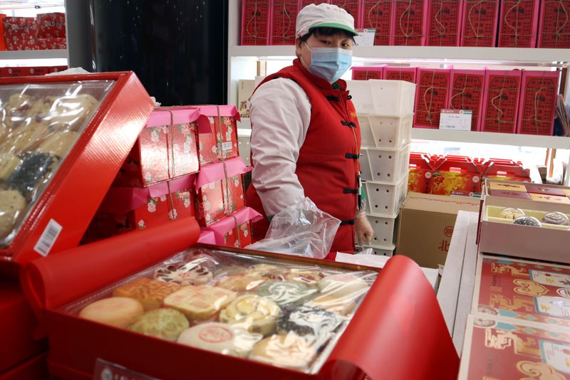 Staff member stands behind Lunar New Year gift sets at