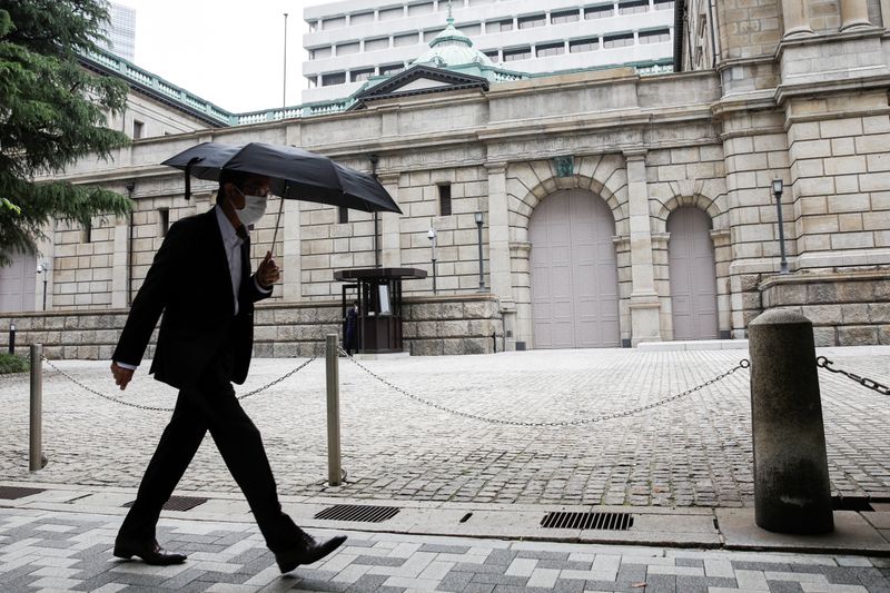 FILE PHOTO: A man wearing a protective mask walks past