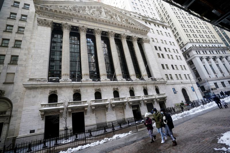 FILE PHOTO: People walk past the New York Stock Exchange