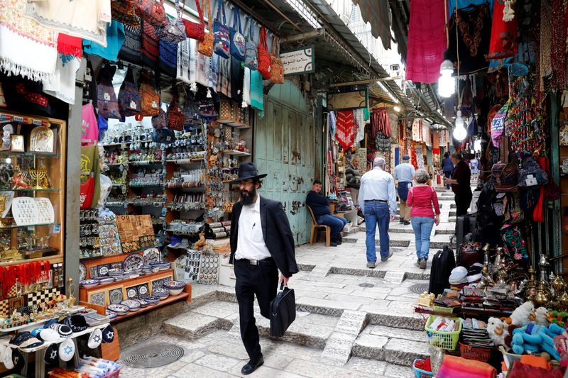 People walk around an alley in Jerusalem’s Old City