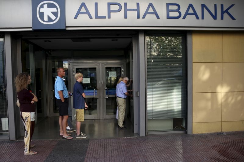 People line up at an ATM outside an Alpha Bank