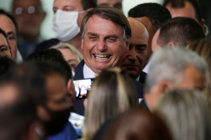 FILE PHOTO: Brazil’s President Jair Bolsonaro smiles near mayors after