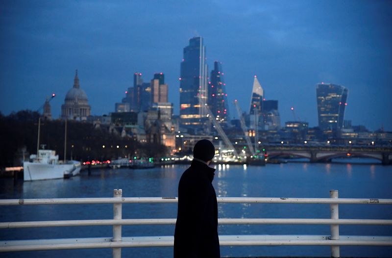 A man looks towards skyscrapers of the City of London