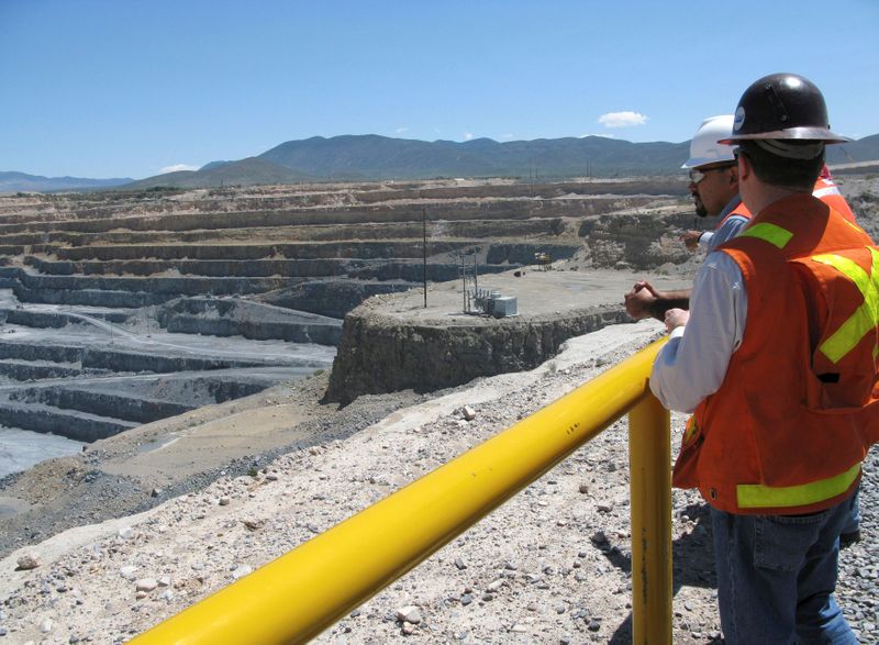 FILE PHOTO: Engineers stand next to the open pit gold