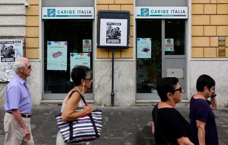 People walk past a Carige bank in Rome