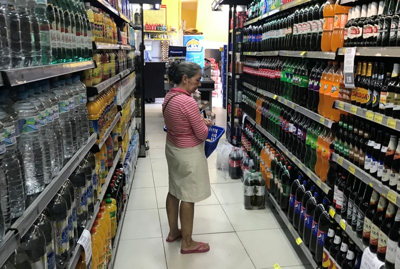 A costumer looks for drinks at a supermarket in Rio