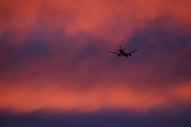 FILE PHOTO: FILE PHOTO: A plane flies in a red