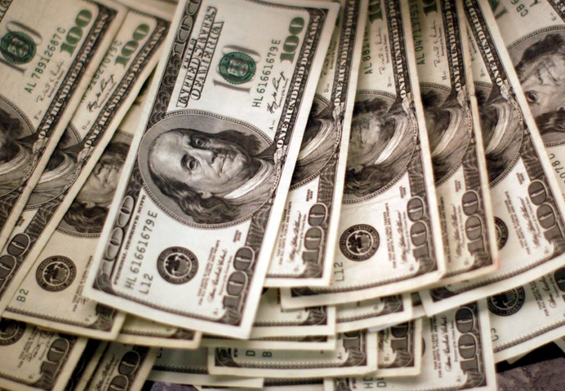 FILE PHOTO: U.S. dollars are counted out by a banker