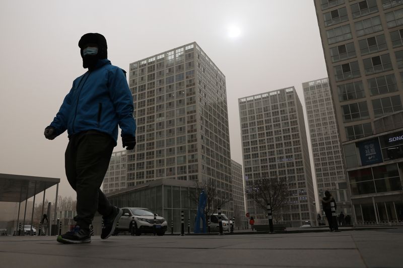 Delivery worker wearing a face mask walks past an office