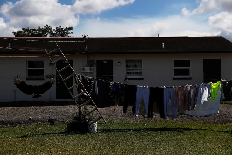 Clothes hang outside to dry behind an apartment as a