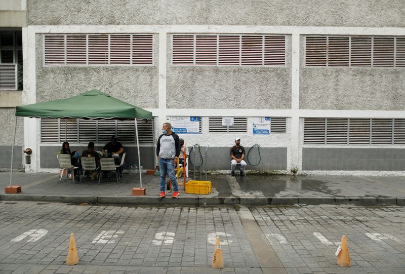 Workers from the municipality of Chacao wait for residents to