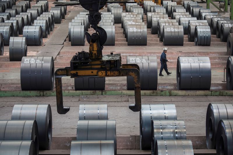 FILE PHOTO: Worker walks past steel rolls at the Chongqing