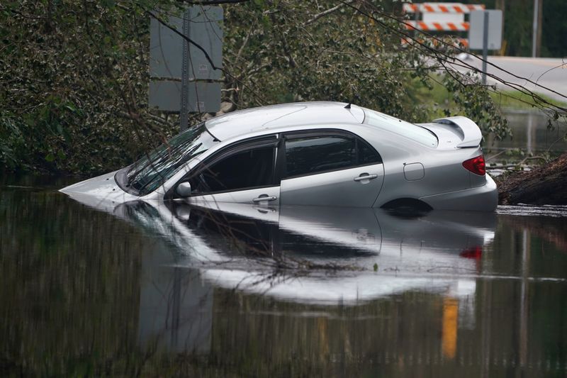 FILE PHOTO: Partially submerged car is pictured on flooded street