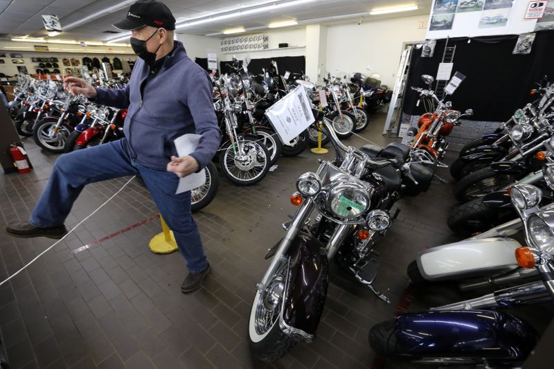 FILE PHOTO: Gary Haines places SOLD signs on Harley Davidson