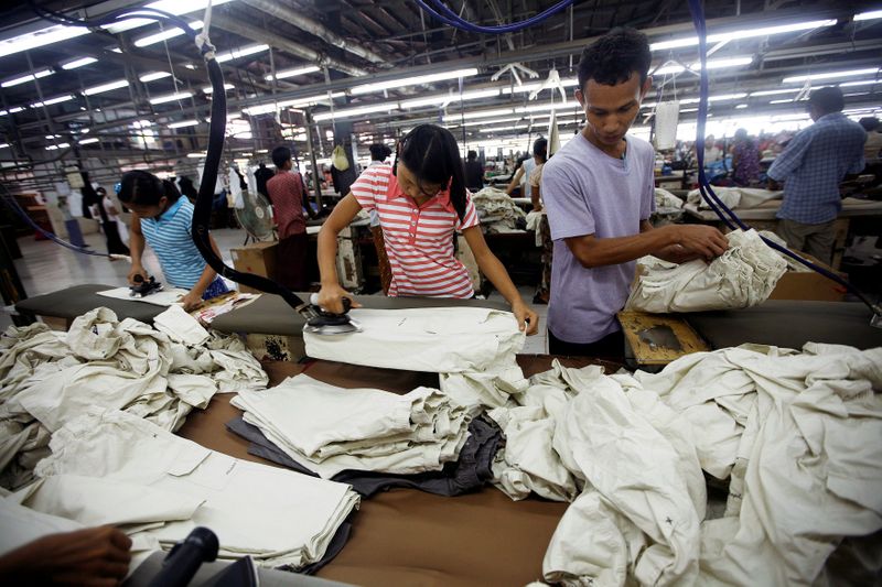 FILE PHOTO: Workers iron and arrange clothing at a garment