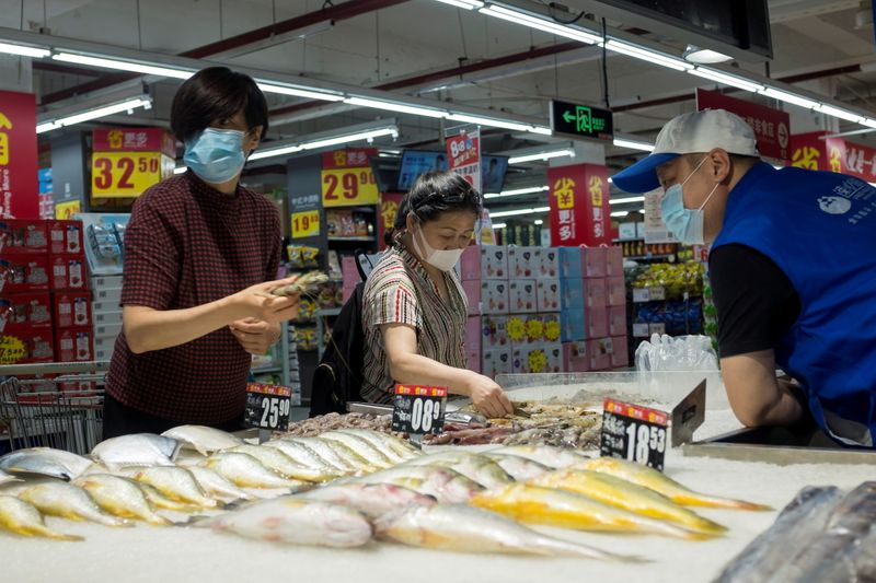 FILE PHOTO: People look at fresh seafood in a supermarket