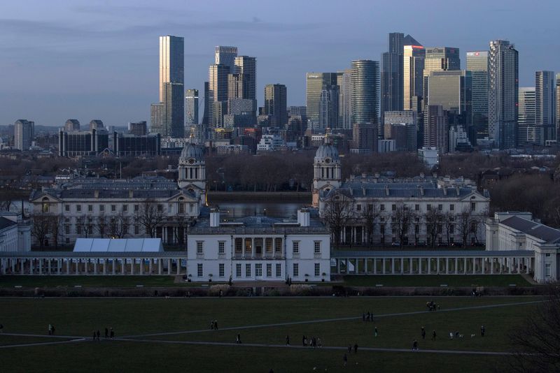 Canary Wharf stands beyond the Maritime museum from Greenwich Park