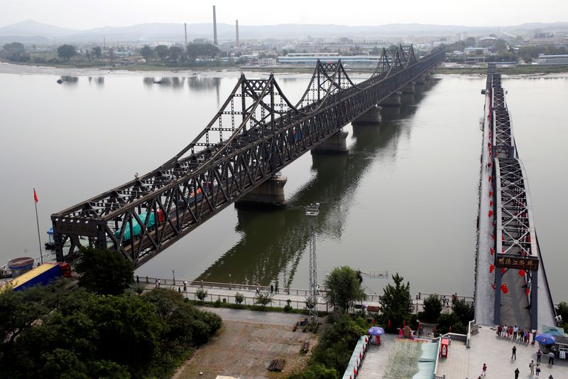 FILE PHOTO: Trucks cross Friendship Bridge from China’s Dandong, Liaoning